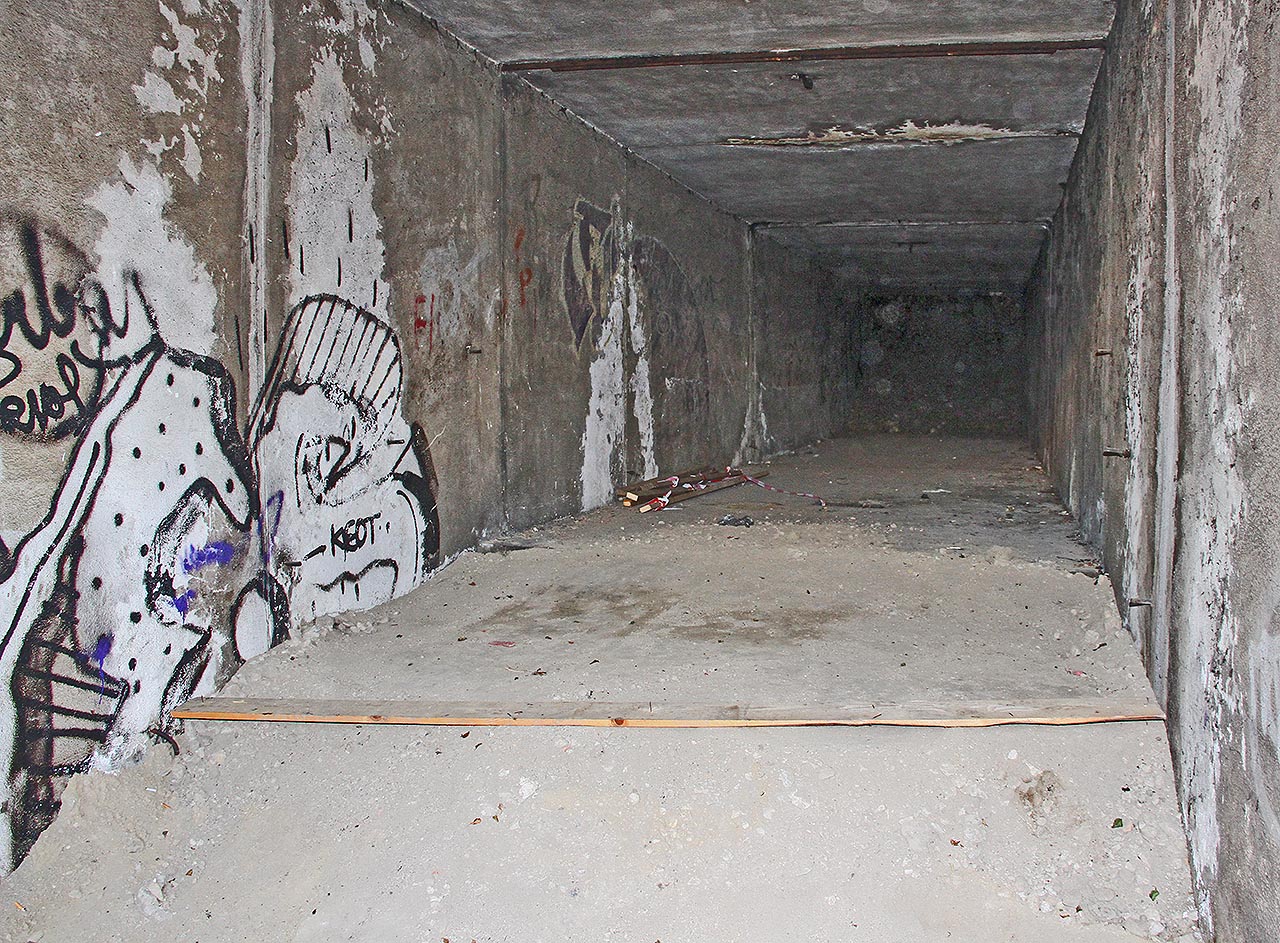 Přístřešek nad schodištěm na východní straně (v kolejišti stanice) byl zdemolován a suť byla postupně vrstvena a pěchována mezi stěny podchodu, které zůstaly v podzemí.