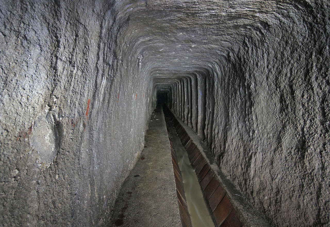 Pohled do betonem nastříkané kanalizační štoly pod Jurankou. Kyneta ve dně je obložena keramickými dlaždicemi s vyšší chemickou odolností proti agresivním splaškům.