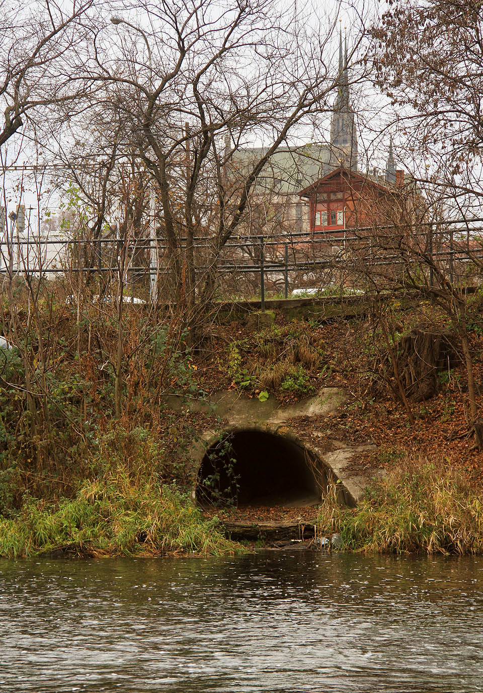 Pohled na odlehčovací komoru OKB05 přes řeku Svratku. Z místa pod železničním mostem by se mohlo zdát, že komora patří společně s chrámem svatých Petra a Pavla a hlavním železničním nádražím k dominantám Brna.