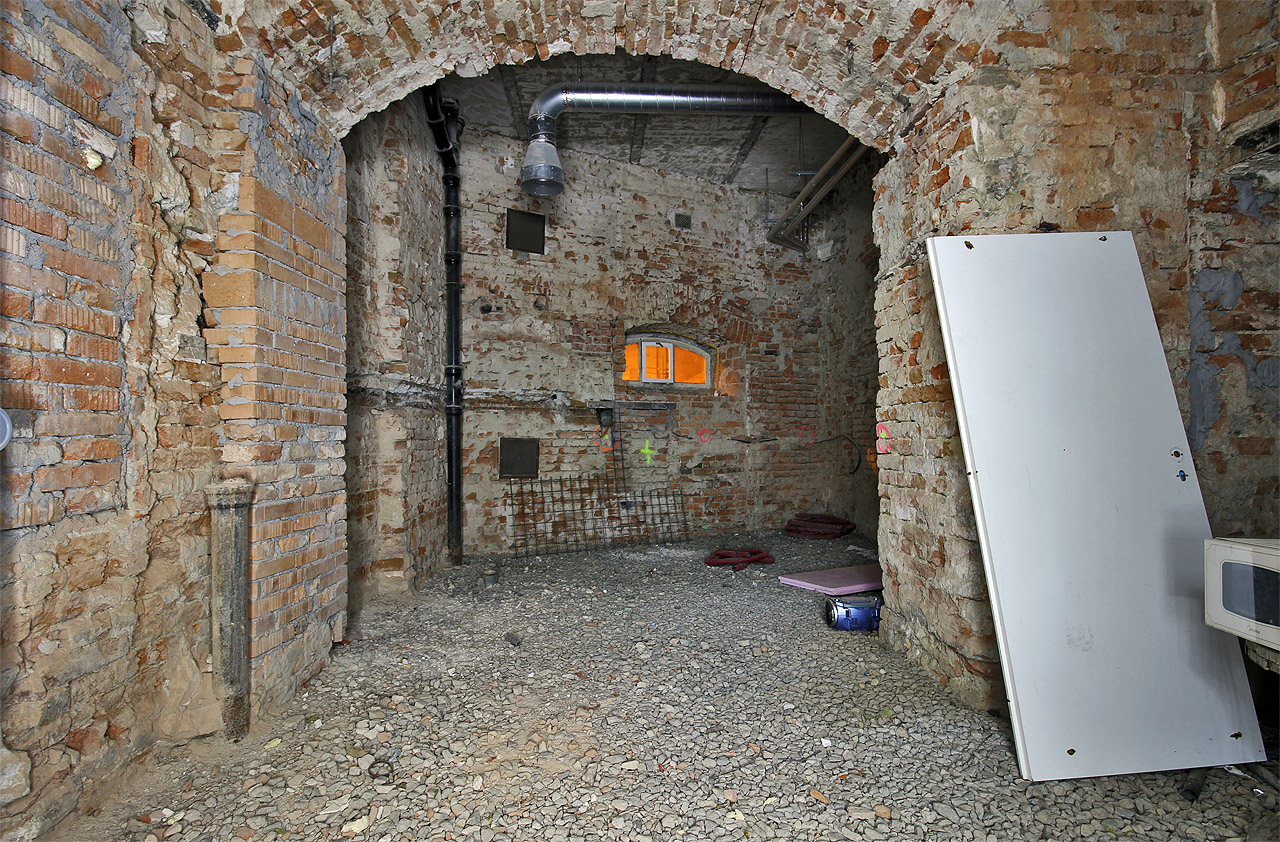 Do sklepů vede několik okének z prostoru pod viaduktem, který tvoří jakýsi portál vstupu do města v empírovém stylu.