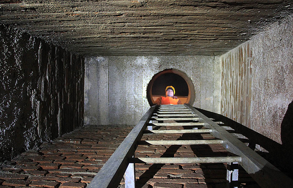 Pan inženýr se shora dívá do moderní vyzděné šachty, která spojuje podzemí s povrchem.