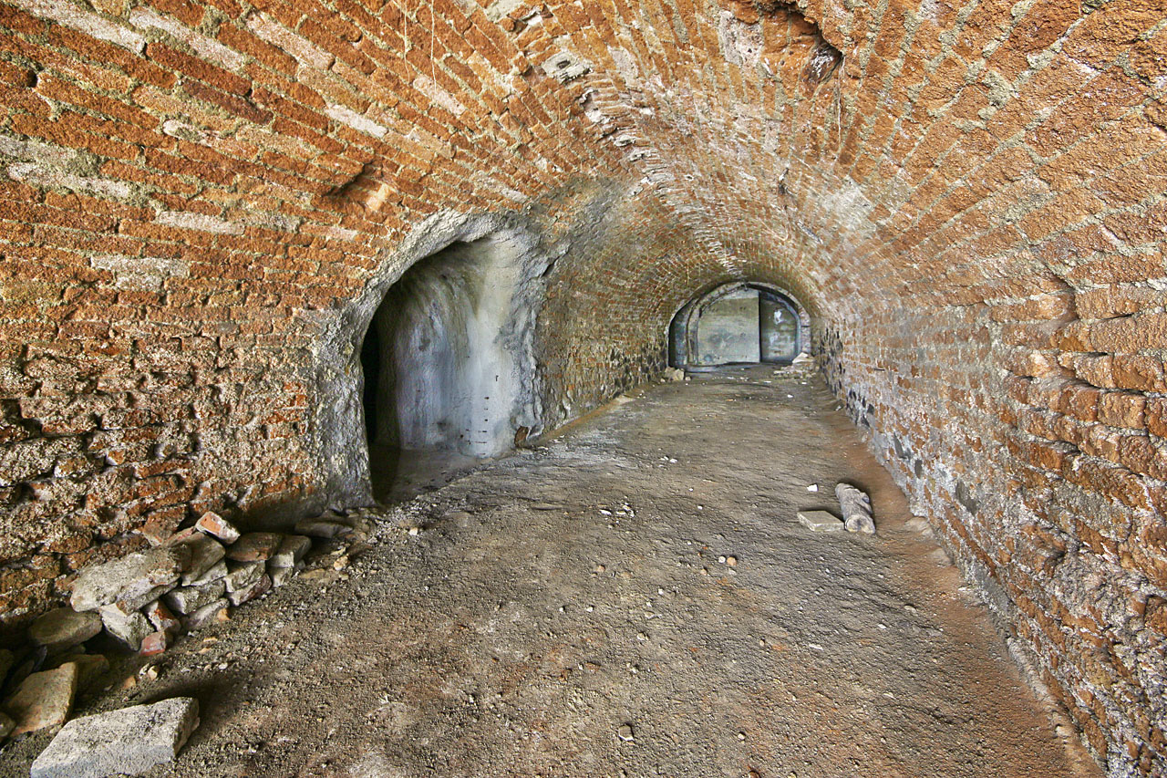 Pohled páteřní chodbou k jihu. Vlevo odbočuje chodbice do prostředního sálu, v pozdaí odbočka do jižního z trojice sálů a protitlaková stěna.