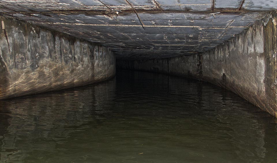 Nedaleko za vtokem se vodní tunel stáčí mírným obloukem doleva. Hukot padajících vod sílí a tak míříme kuželem baterky do neprostupné tmy na konci tunelu, abychom vodopád spatřili včas.