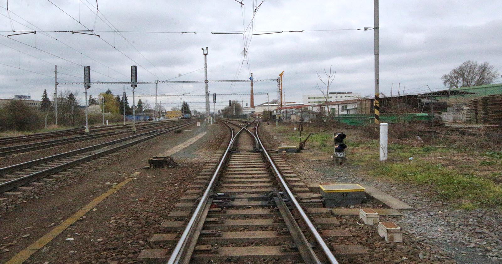 Pohled ze severního (Heršpického) zhlaví stanice Modřice směrem k cihleně. Z výhybky č. 17 (pod fotografem) je vidět výhybku č. 16 a vpravo od ní výhybku č. 14, ze které odbočuje a do vrat vchází kolej vlečky společnosti Firesta. Tudy vjížděly do areálu překladiště nákladní vlaky, aby se pak úvraťově vrátily k severu, k rampě úzkokolejky (je vidět na fotce vpravo).