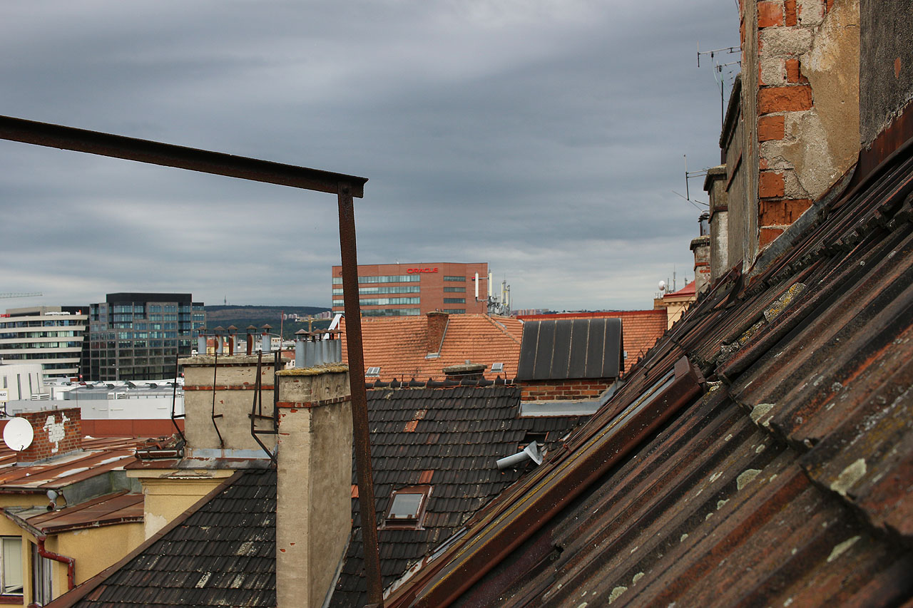 Také střechy domu skýtaly romantický pohled na měnící se Brno. Střechy s atikami, terasami, komíny a anténami mizí, aby uvolnily místo kvádrům a hladkým plochám skleněných oken.